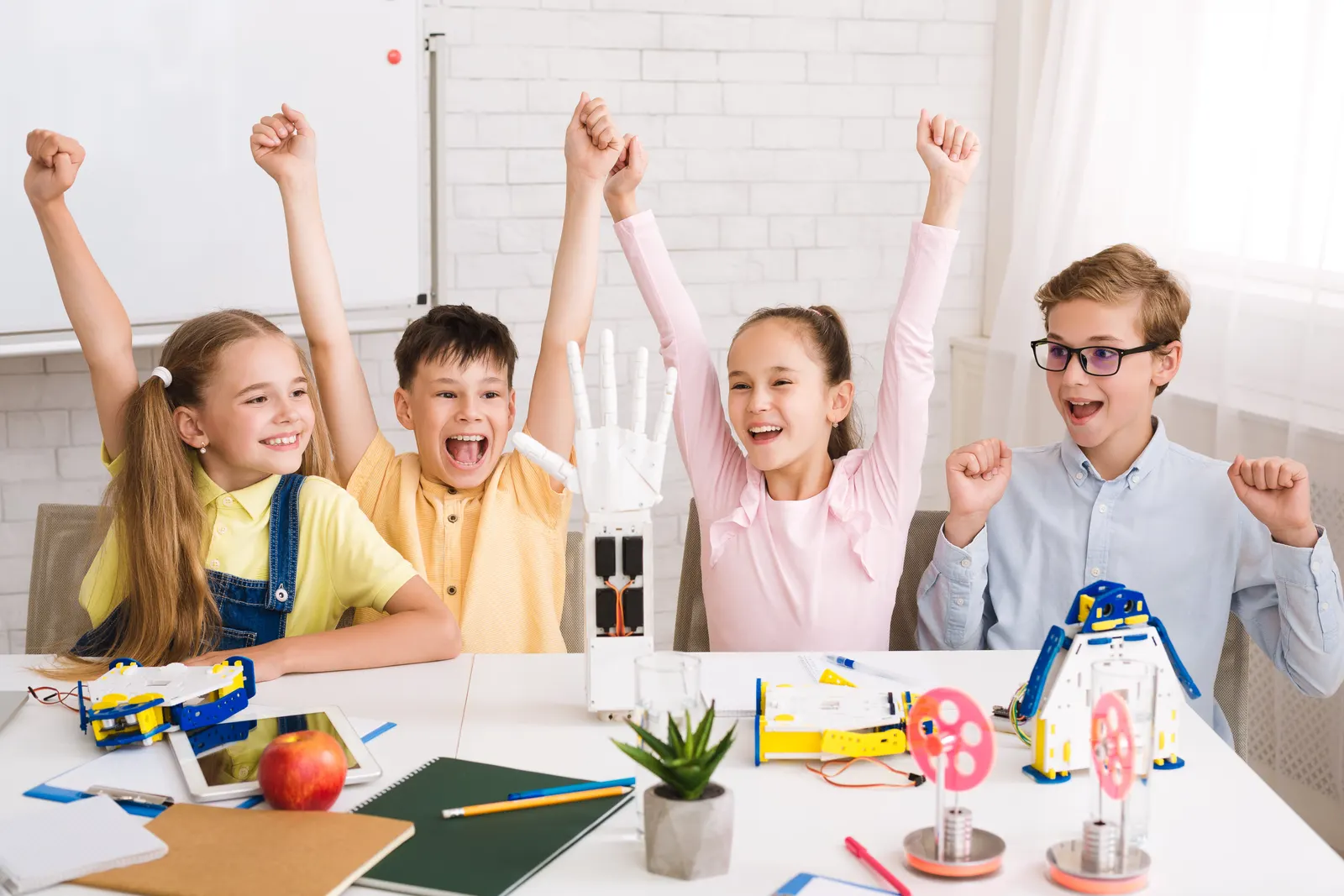 Four children cheering over the models they have built