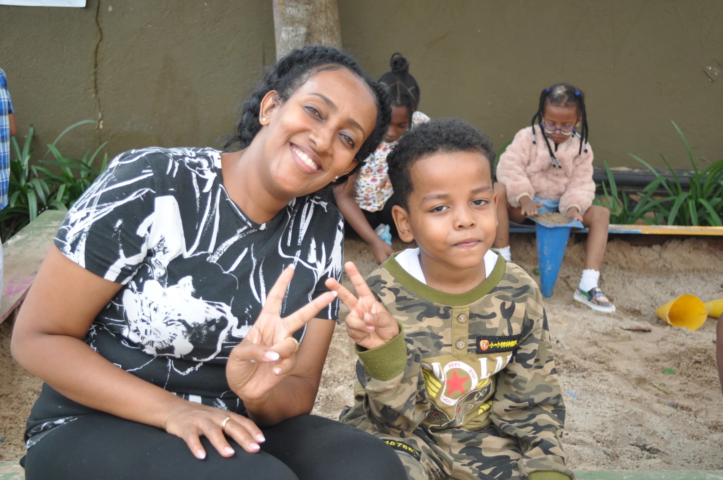 An Eco-Bloom pupil and an adult smiling together during community day