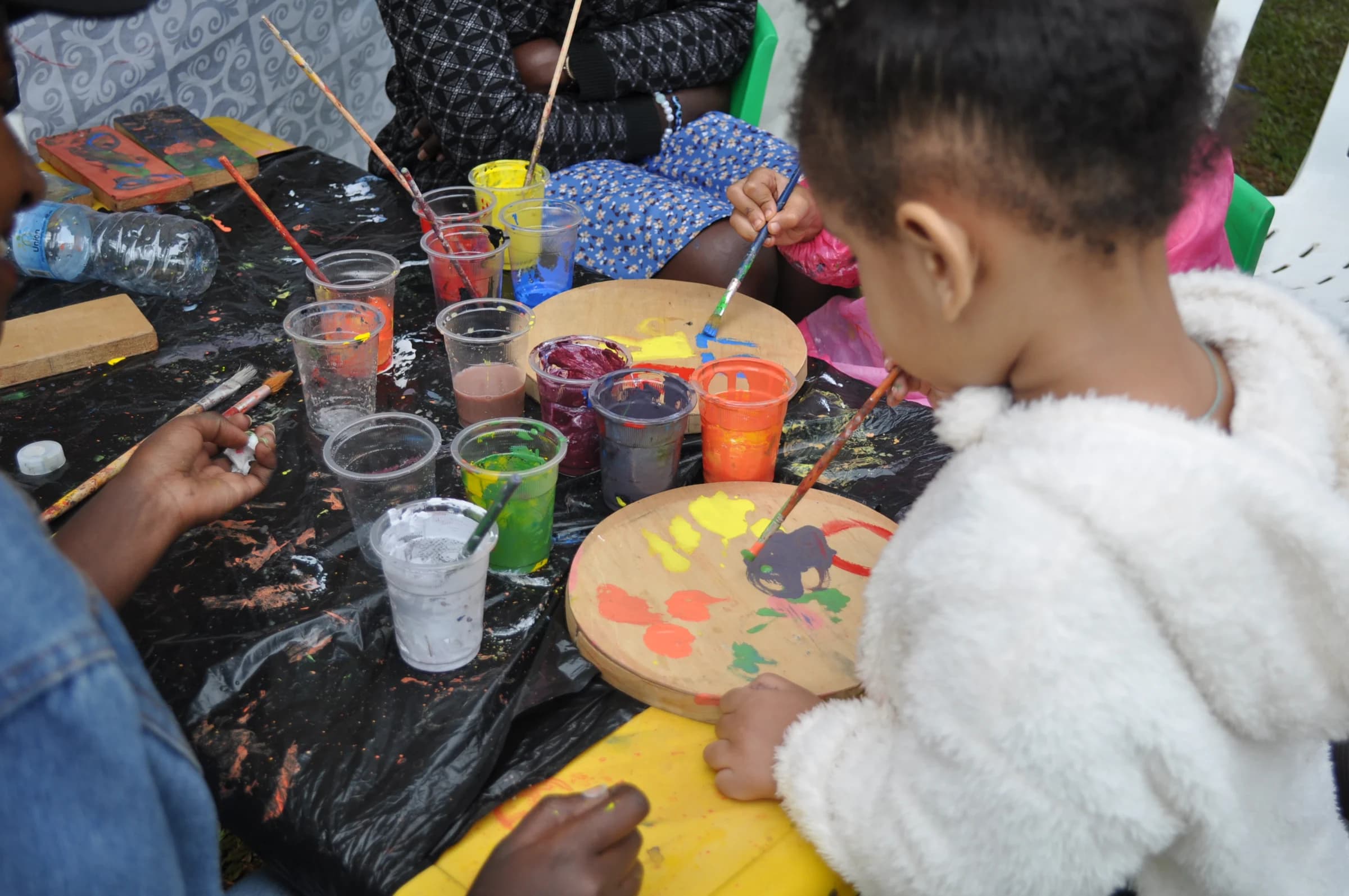 Eco-Bloom children painting colourful wooden artwork together