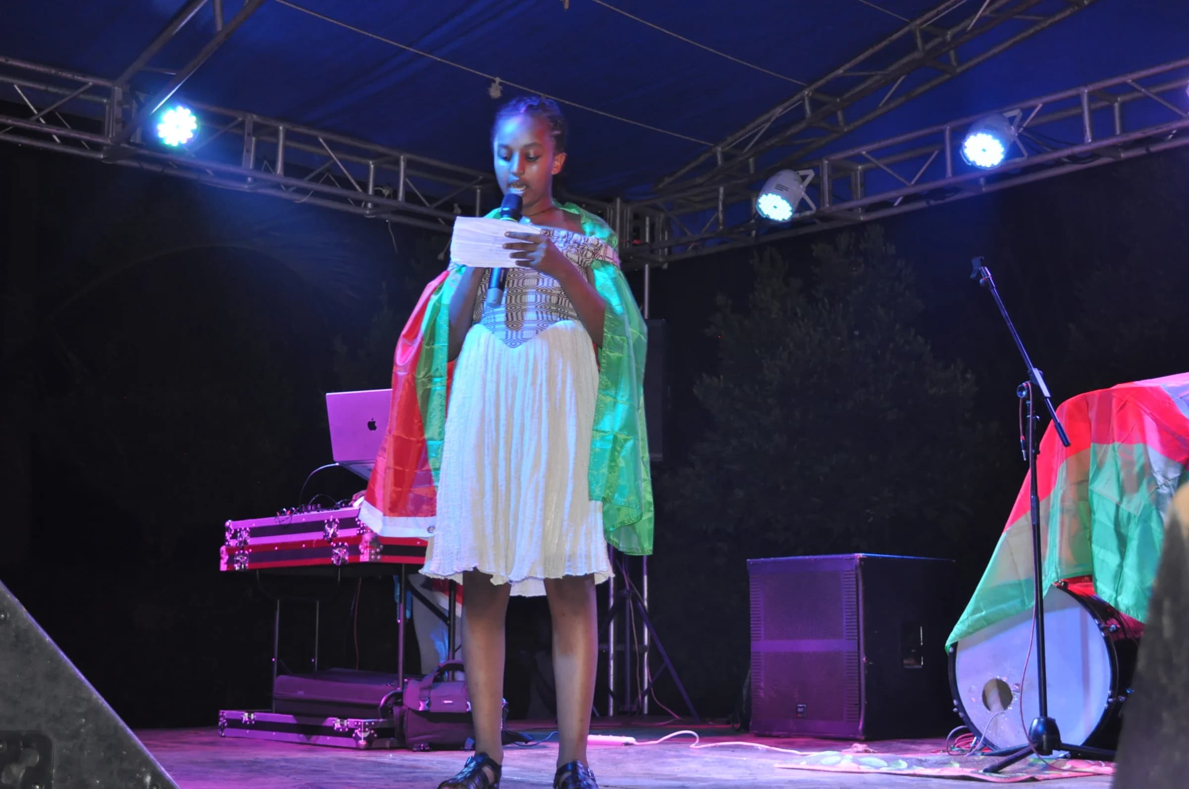 An Eco-Bloom pupil speaking into a microphone during the cultural celebration