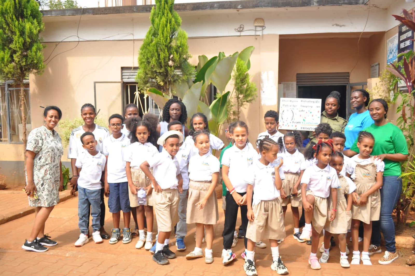 Eco-Bloom pupils and adults posing with police officers during their Kabalagala visit