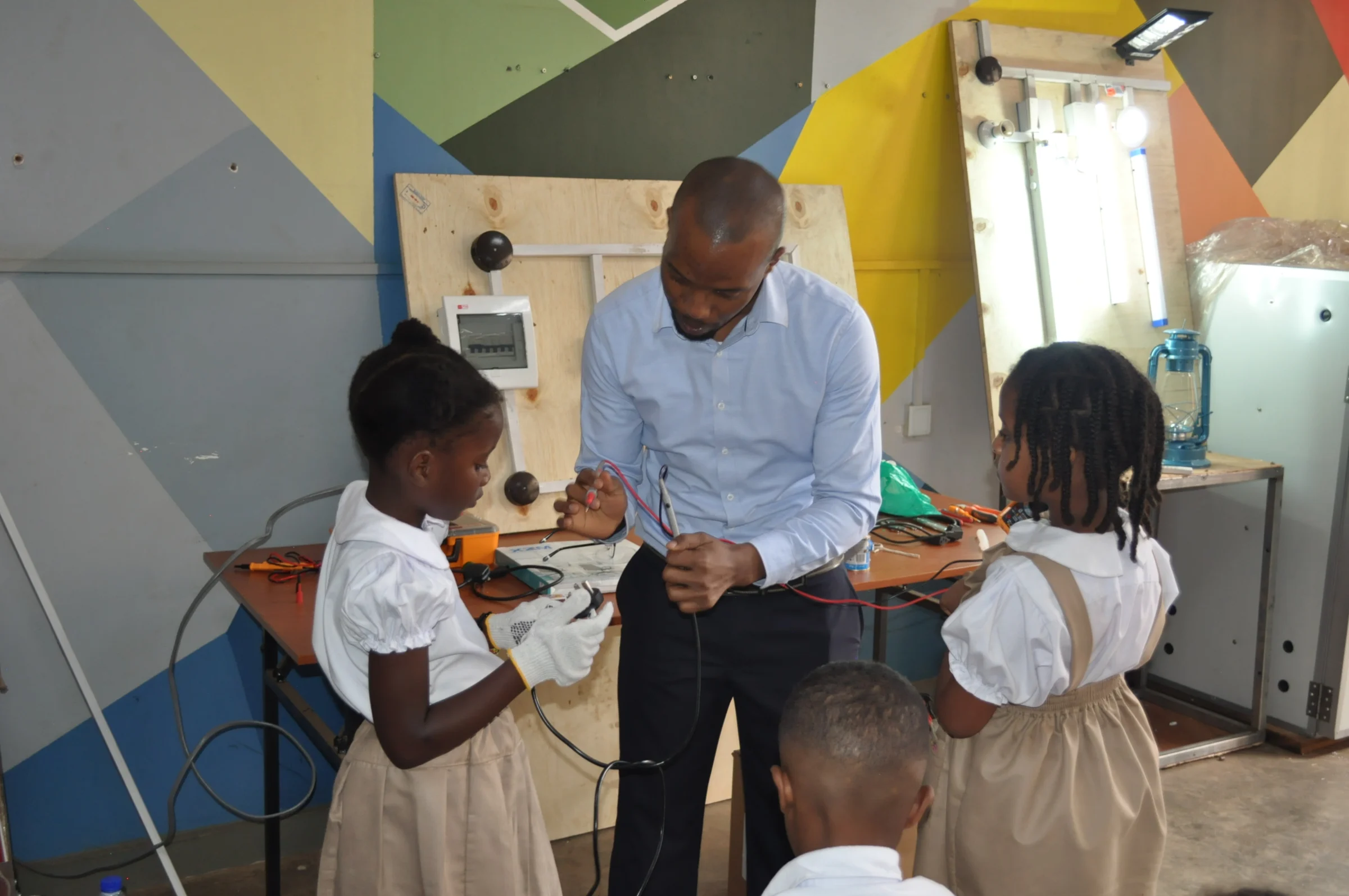 Eco-Bloom pupils learning to use electrical test equipment at Makerere University