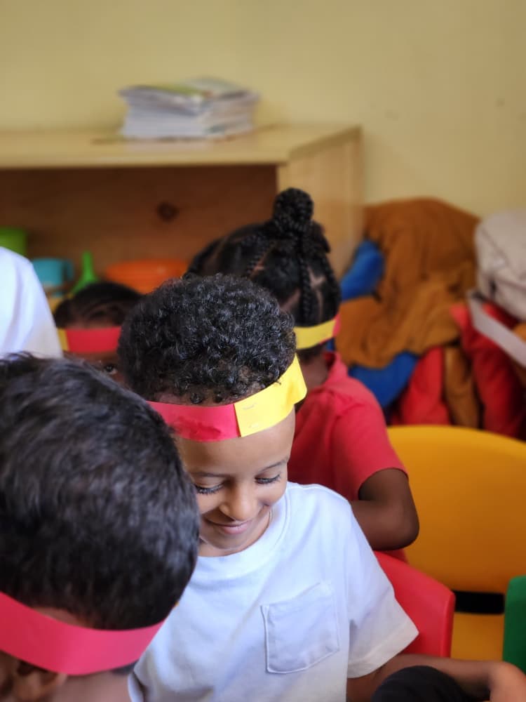 A pupil smiling in a red and yellow headband