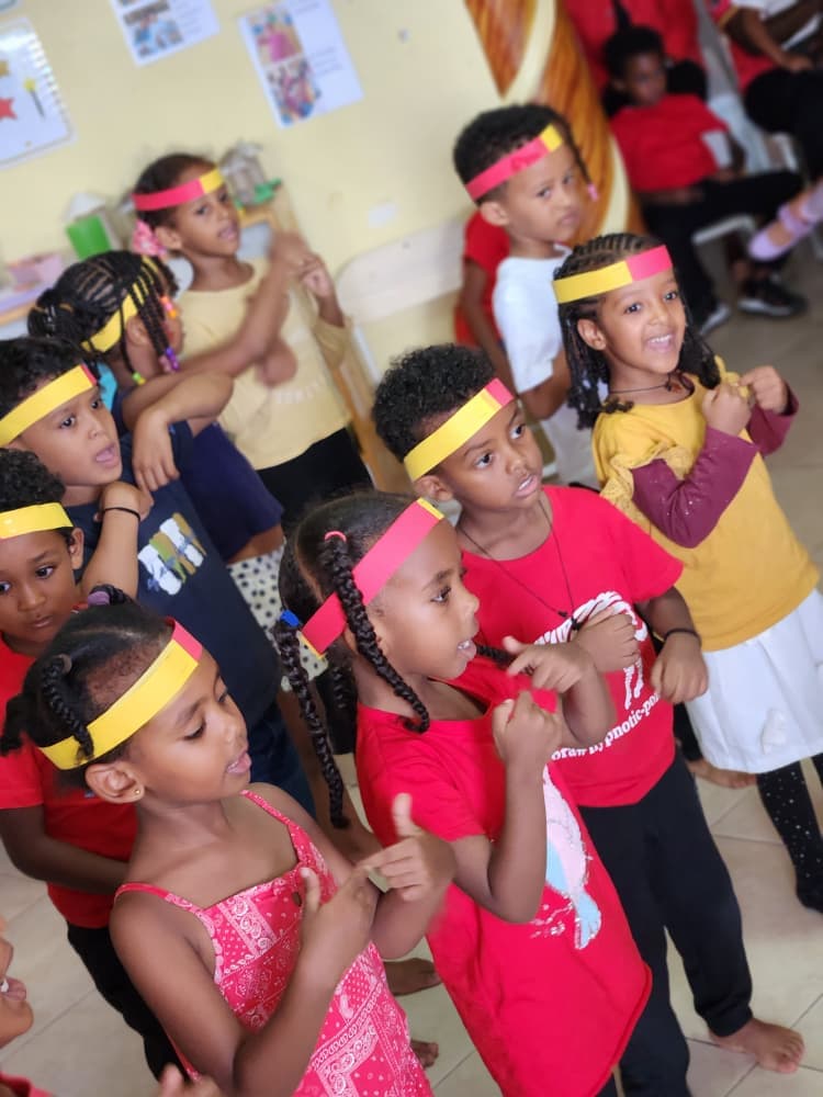 Children singing and moving together in Uganda colours