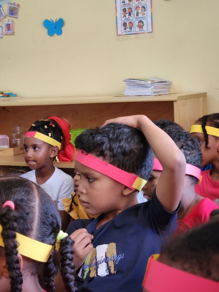 A pupil adjusting a Uganda-coloured headband