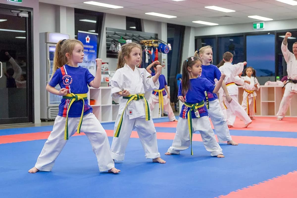 Young children practising karate in coloured belts