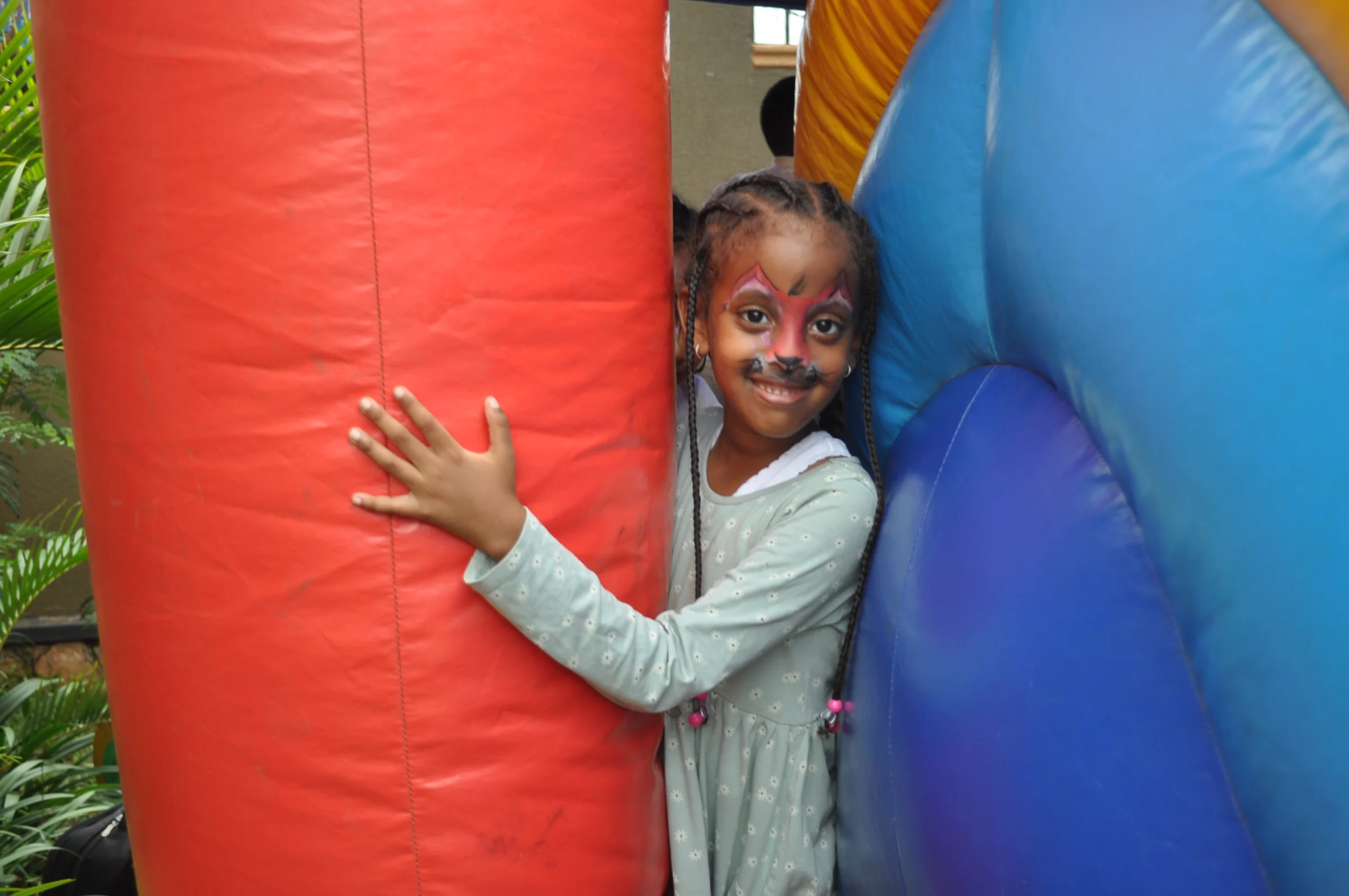 An Eco-Bloom pupil smiling while playing on the inflatable castle